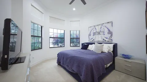 a bedroom with a large bed and a flat tv screen on a dresser