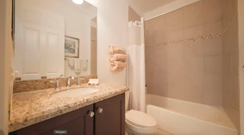 a bathroom with a granite countertop sink a toilet and shower