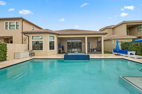a view of a swimming pool with couches chairs and swimming pool