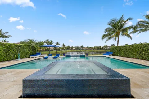 a view of a house with backyard and swimming pool