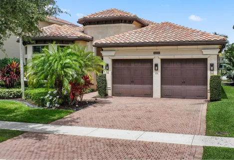 a front view of a house with a garden and plants