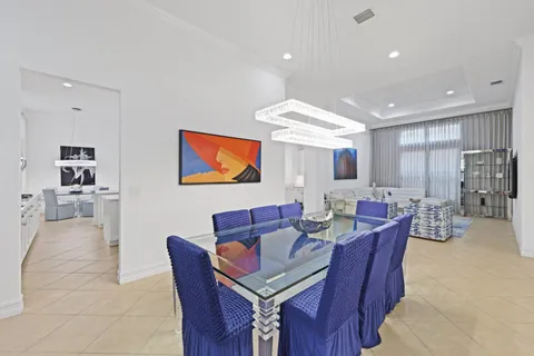 a living room with furniture a flat screen tv and kitchen view