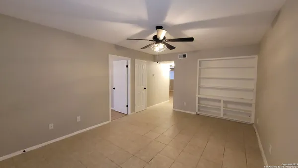 a view of an empty room with a ceiling fan