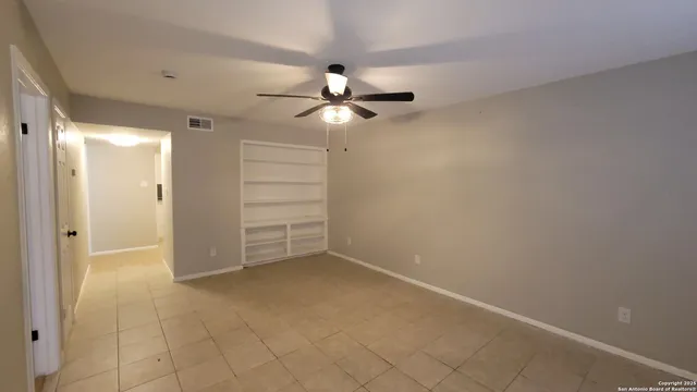 an empty room with closet and a ceiling fan