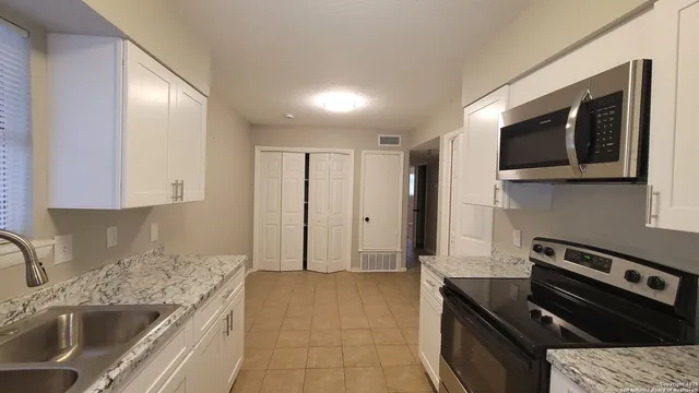 a kitchen with stainless steel appliances granite countertop a sink stove and cabinets