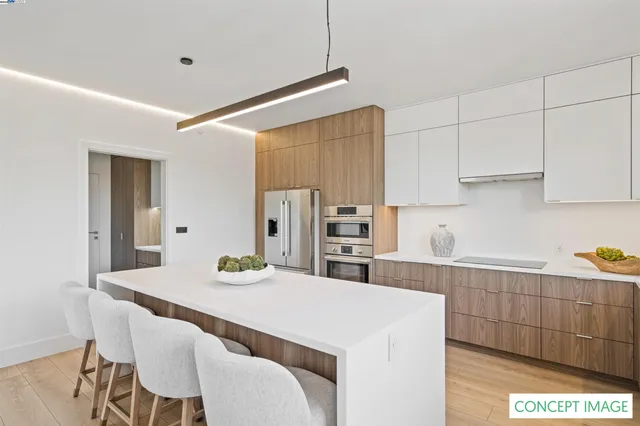 a kitchen with stainless steel appliances kitchen island granite countertop a table chairs and a refrigerator