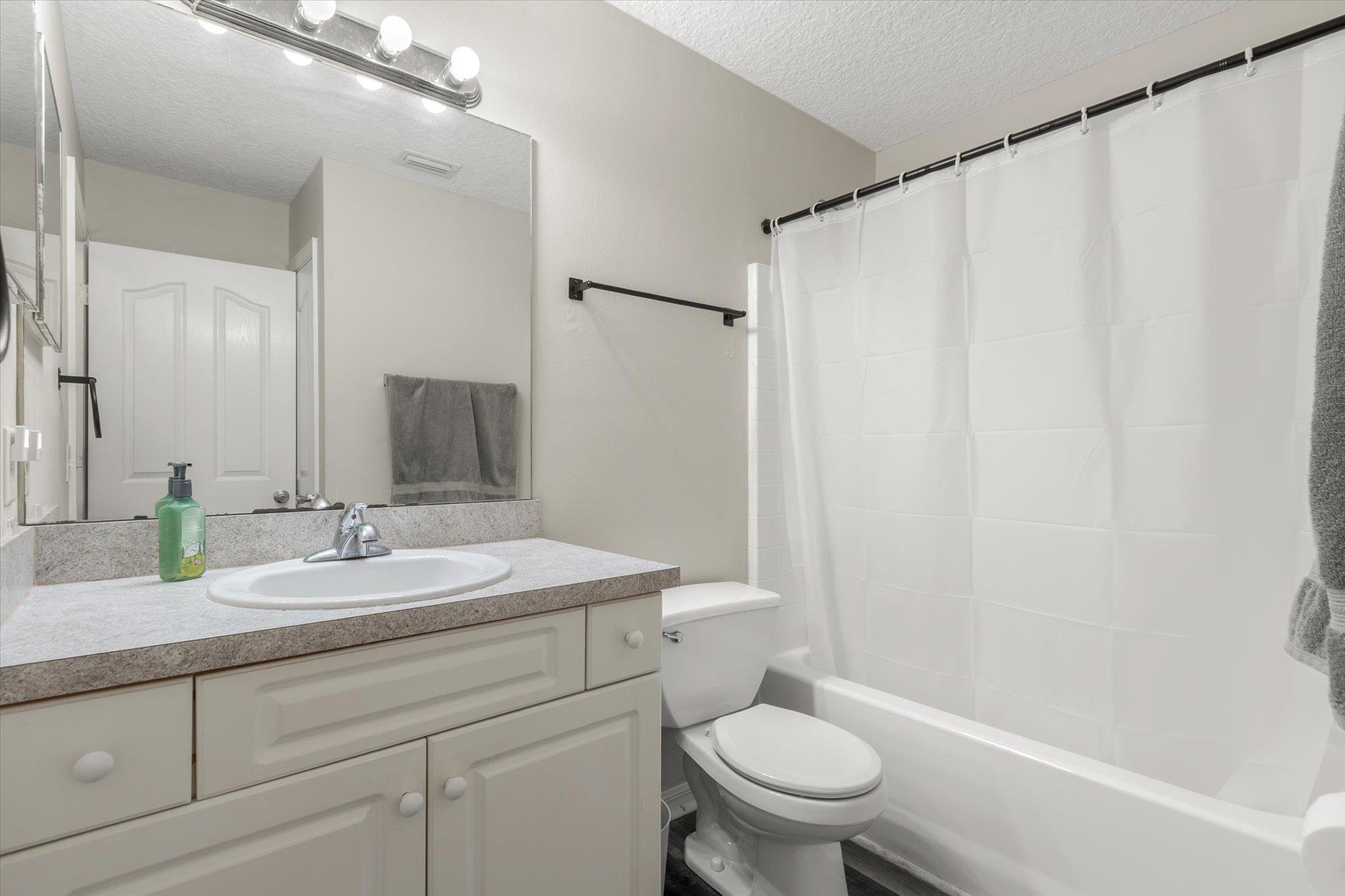 3372 4th Street Elkton, FL 32033 - Photo 15 of 36 Bathroom with a textured ceiling, vanity, and shower / bath combo