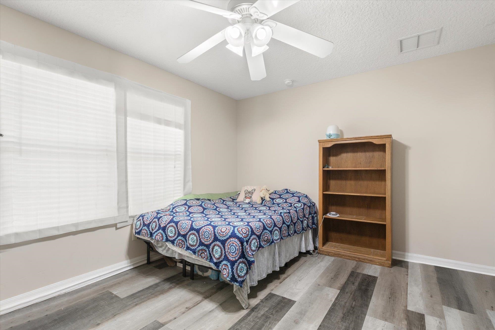 3372 4th Street Elkton, FL 32033 - Photo 17 of 36 Bedroom with light wood-type flooring, ceiling fan, and a textured ceiling