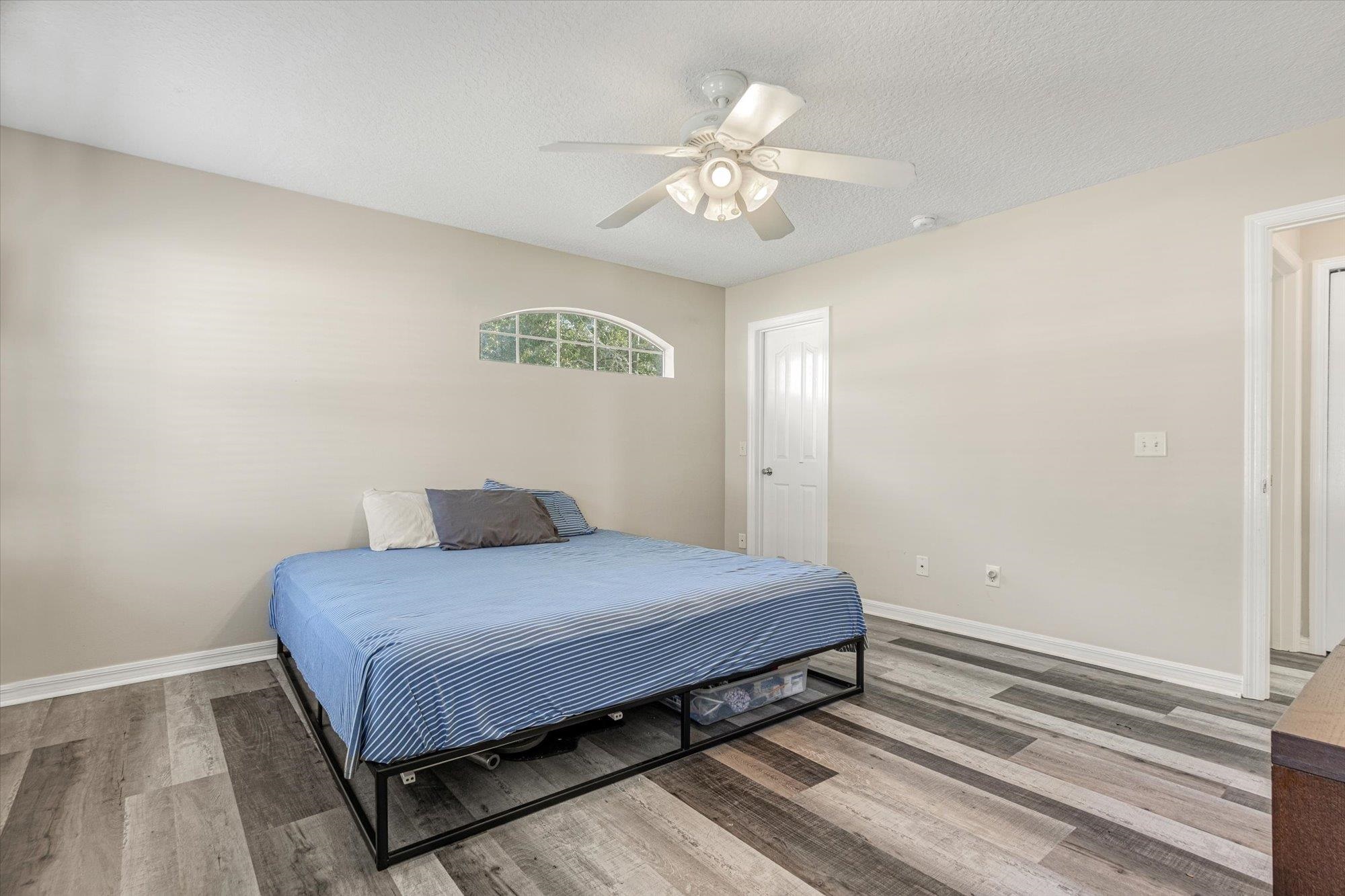 3372 4th Street Elkton, FL 32033 - Photo 20 of 36 Bedroom featuring wood finished floors, a textured ceiling, and a ceiling fan
