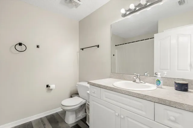 a bathroom with a sink a toilet and mirror
