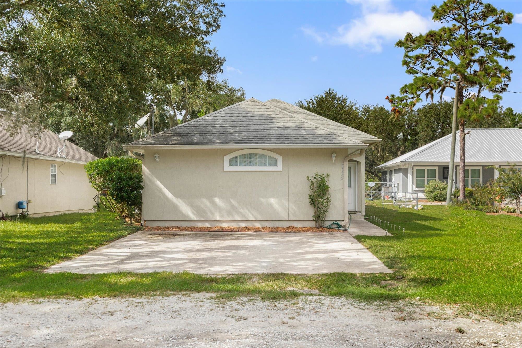 3372 4th Street Elkton, FL 32033 - Photo 30 of 36 Rear view of house with a yard and roof with shingles
