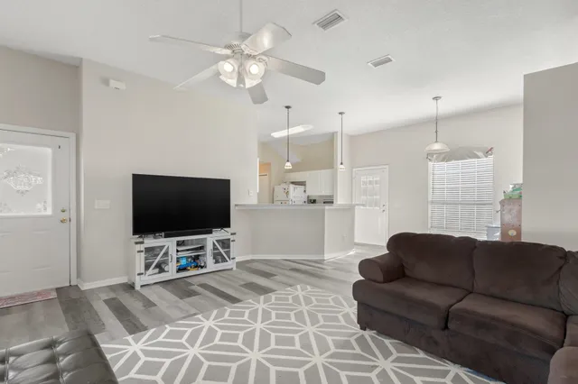 a living room with furniture a flat screen tv and a large window