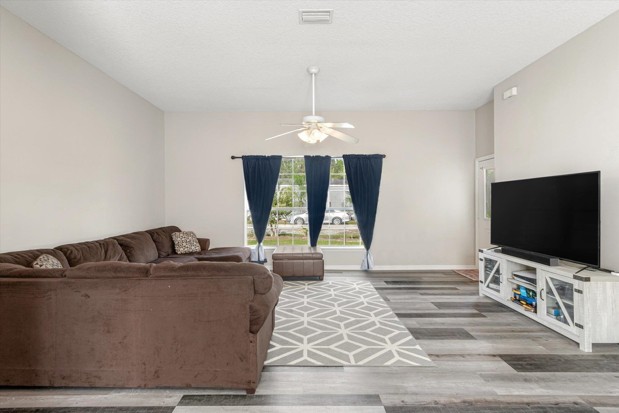 3372 4th Street Elkton, FL 32033 - Photo 5 of 36 Living room featuring light wood-type flooring, a ceiling fan, and a textured ceiling
