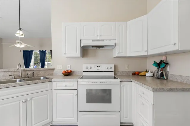 a kitchen with white cabinets and white appliances