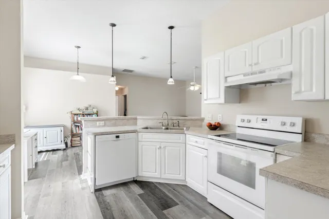 a kitchen with white cabinets sink and white appliances