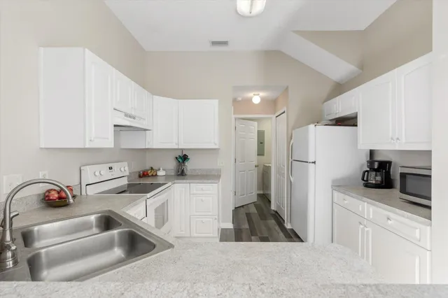 a kitchen with white cabinets and a sink
