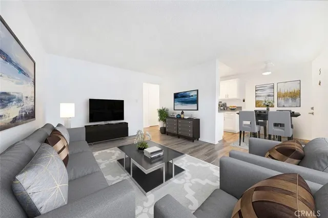 a living room with furniture kitchen view and a flat screen tv