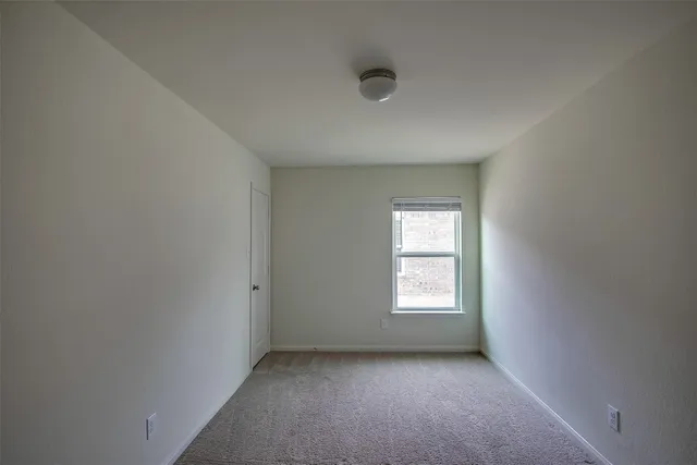 an empty room with a window and fireplace