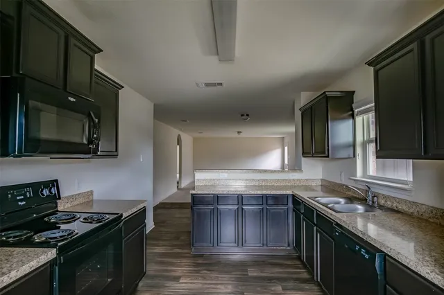a kitchen with stainless steel appliances granite countertop a stove and a sink