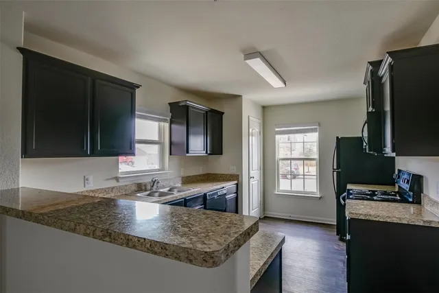 a kitchen with stainless steel appliances granite countertop a sink stove and microwave