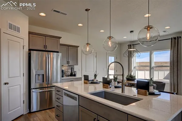 a kitchen with kitchen island a counter space a sink appliances and cabinets