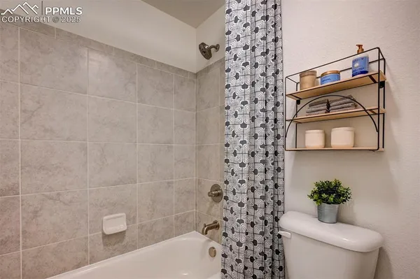 a bathroom with a toilet and a shower curtain