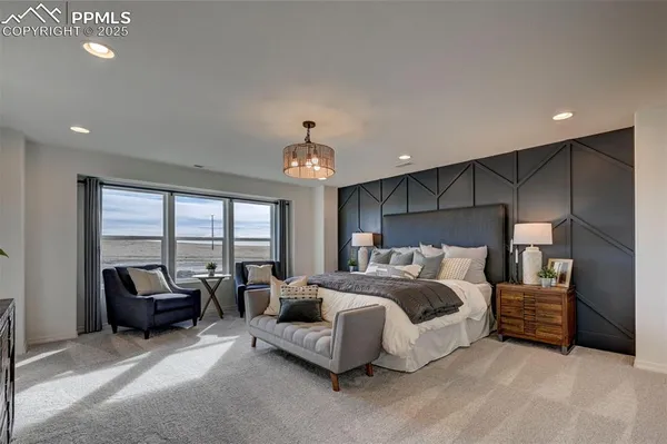a spacious bedroom with a bed a couch and a large window