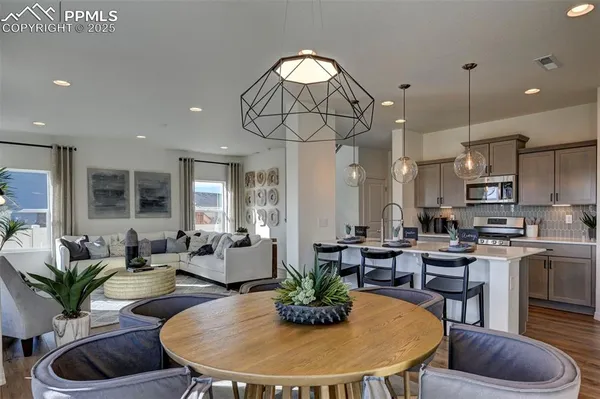 a living room with furniture kitchen view and a chandelier