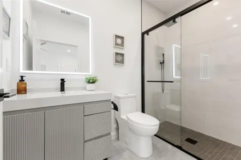 a bathroom with a sink a toilet and shower