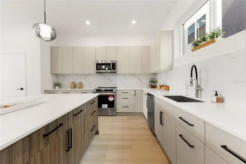 a kitchen with a sink counter top space appliances and cabinets