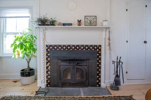 a living room with a fireplace and potted plant