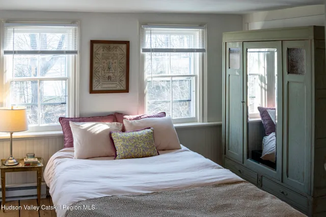 a large bed sitting in a bedroom next to a window