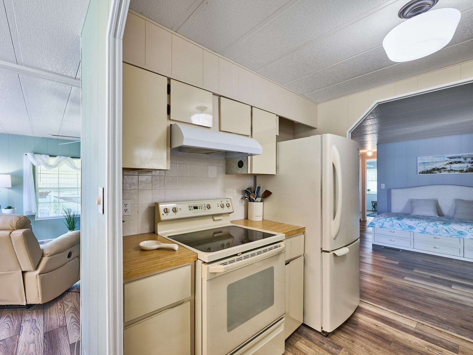6977 Southeast Delegate Street Hobe Sound, FL 33455 - Photo 17 of 60 a kitchen with stainless steel appliances a refrigerator stove and white cabinets