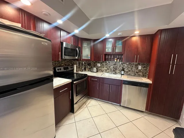 a large kitchen with a large counter space and stainless steel appliances