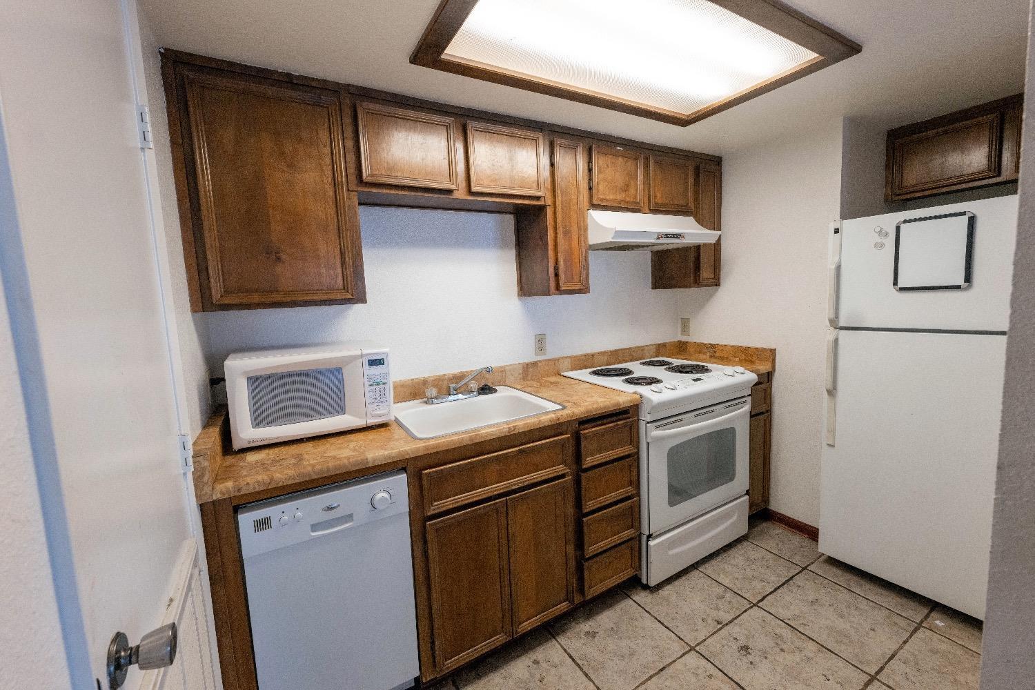 3701 Colonial Drive, Unit 34 Modesto, CA 95356 - Photo 6 of 10 a kitchen with stainless steel appliances granite countertop a stove a sink and a microwave