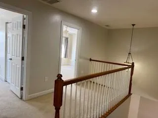 a view of staircase with railing and a window