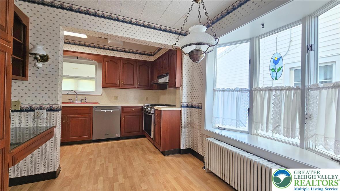 1936 Kemmerer Street Bethlehem, PA 18017 - Photo 11 of 27 a kitchen with stainless steel appliances granite countertop a refrigerator a sink dishwasher a stove and a dining table with wooden floor