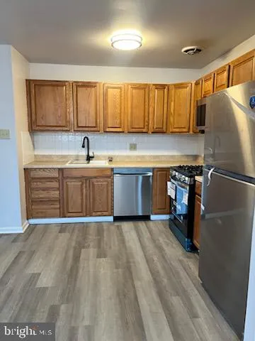 a kitchen with stainless steel appliances granite countertop a refrigerator a sink and a stove