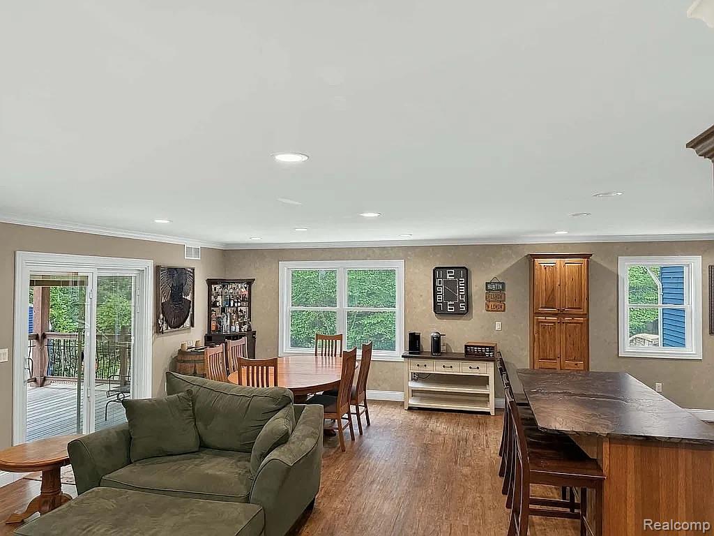 1555 Thompson Road Bad Axe, MI 48413 - Photo 4 of 14 Recessed lighting, wood-finish flooring, white window trim, wood-finish cabinetry, and a sliding glass door