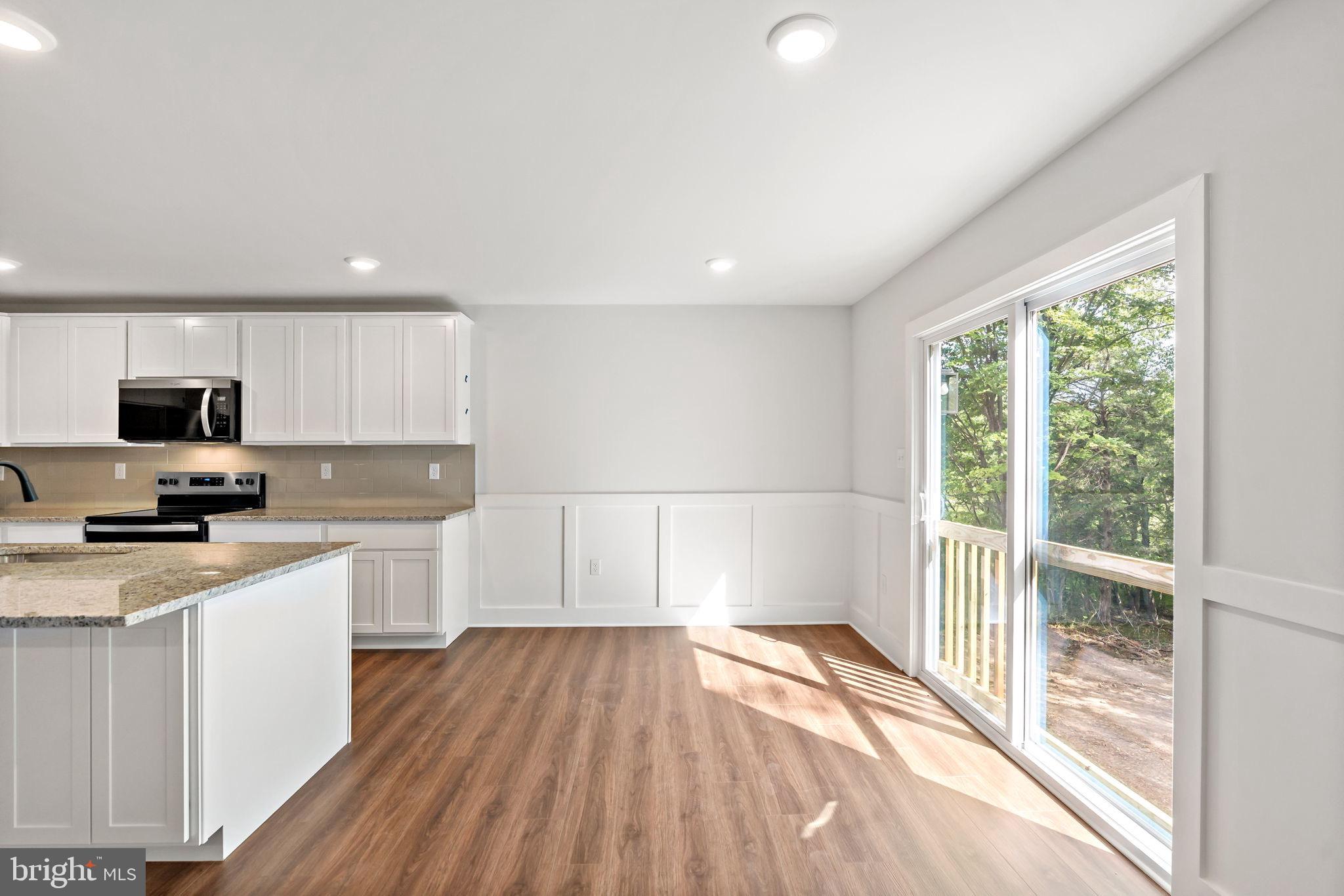 2 Libby's Ridge Road Berkeley Springs, WV 25411 - Photo 14 of 35 a kitchen with wooden floors and white cabinets