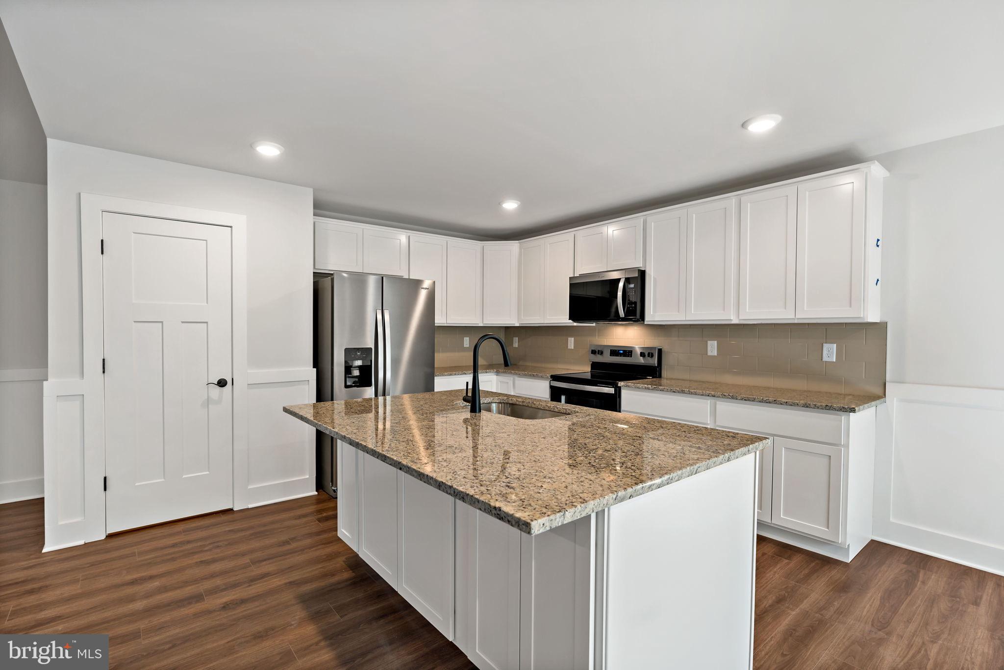 2 Libby's Ridge Road Berkeley Springs, WV 25411 - Photo 3 of 35 a kitchen with stainless steel appliances granite countertop a stove top oven a refrigerator a sink and dishwasher with wooden floor