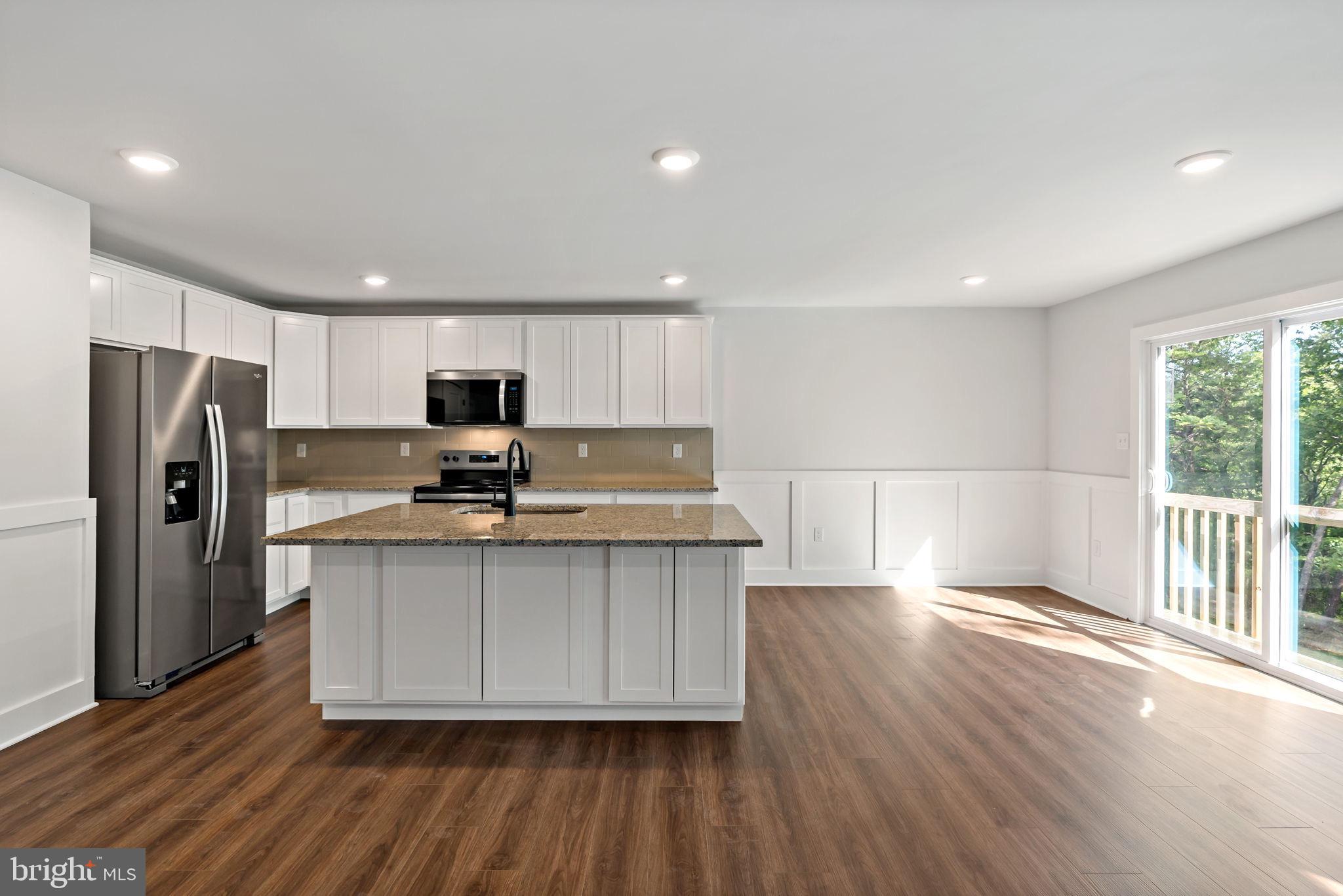 2 Libby's Ridge Road Berkeley Springs, WV 25411 - Photo 4 of 35 a kitchen with stainless steel appliances granite countertop a refrigerator a sink dishwasher a stove and a microwave oven on the wooden floor
