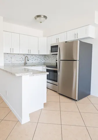 a kitchen with stainless steel appliances granite countertop a refrigerator sink and stove