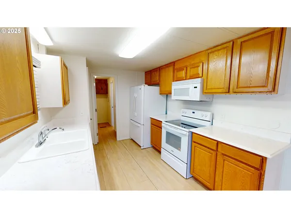 a kitchen with stainless steel appliances kitchen island granite countertop a sink refrigerator stove and microwave