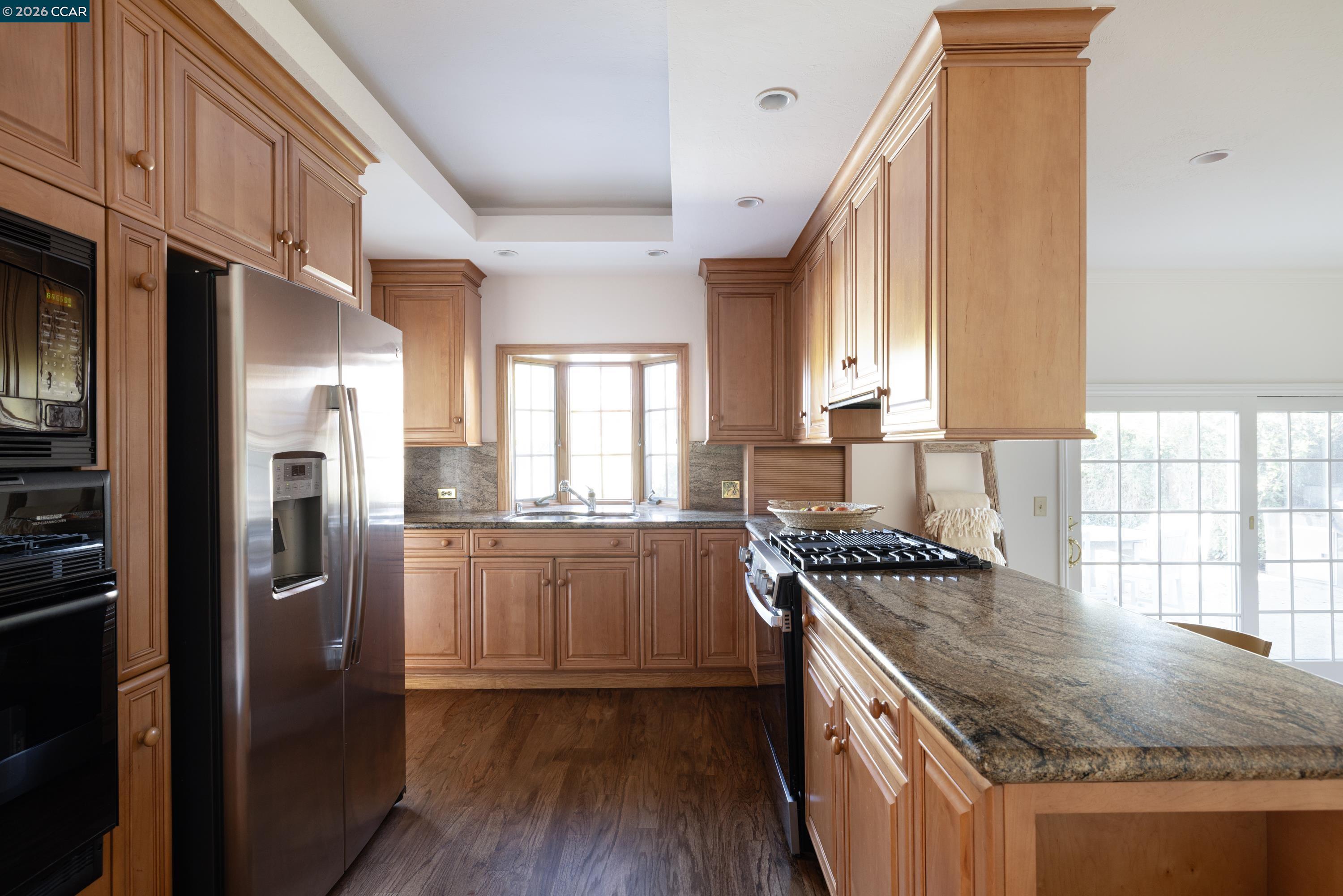 902 Kane Circle Walnut Creek, CA 94598 - Photo 13 of 40 a kitchen with granite countertop stainless steel appliances a sink stove refrigerator and cabinets