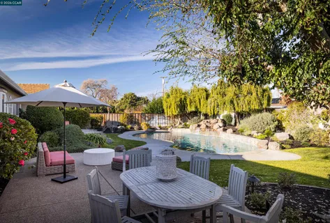 a view of a patio with dining table and chairs and potted plants