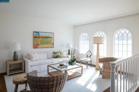 a living room with furniture a fireplace and a chandelier
