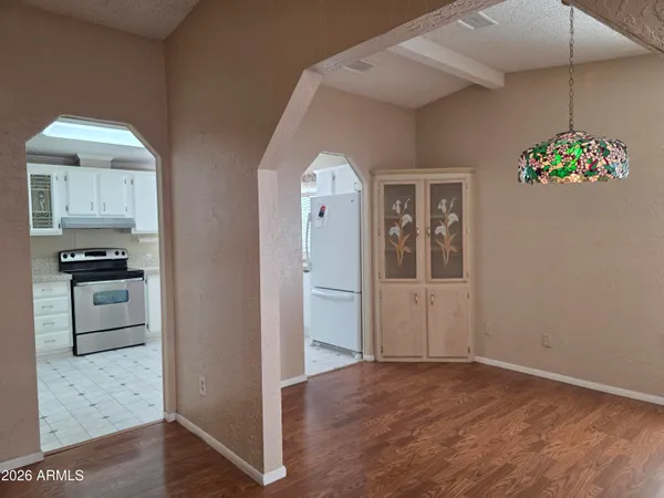 a view of an empty room with window and wooden floor