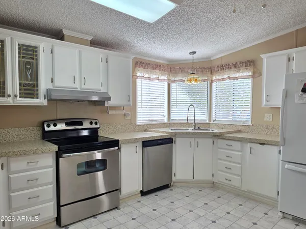 a kitchen with granite countertop white cabinets and white appliances