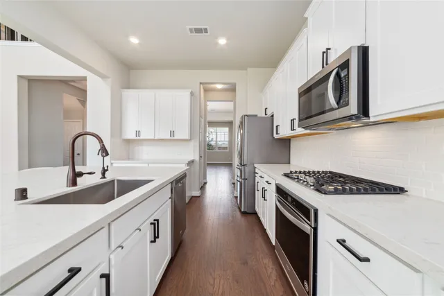 a kitchen with stainless steel appliances granite countertop a sink and stove